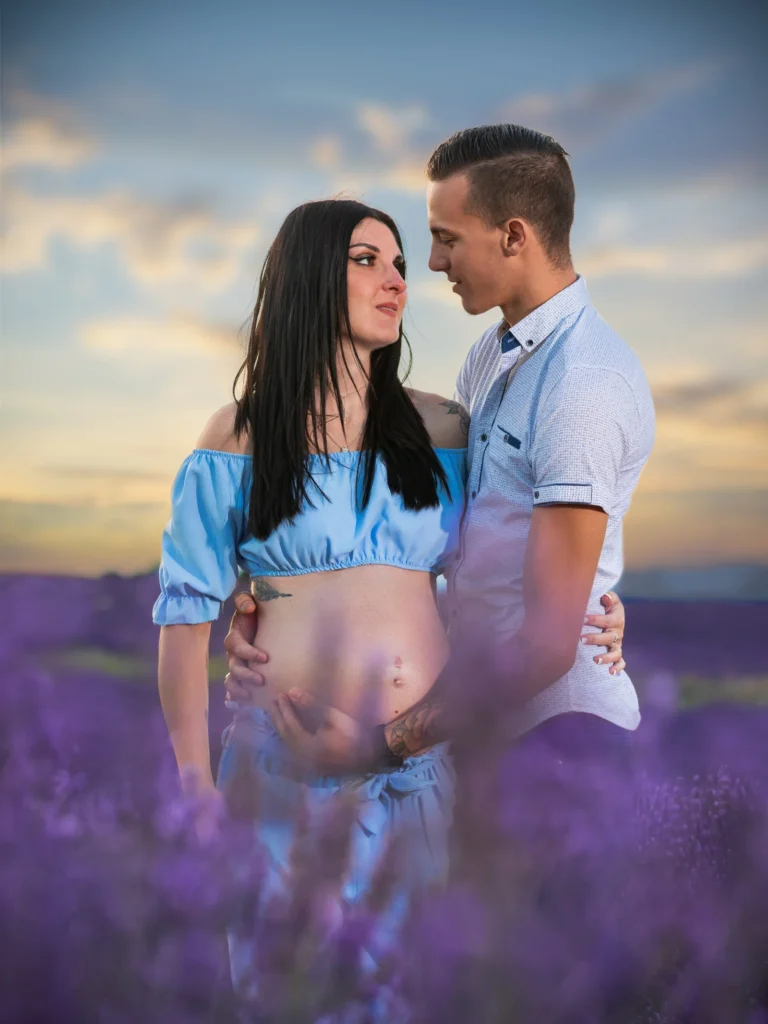 Photographie de grossesse et de fiançailles à Valensole d'Alexandra et d'Axel, au milieu des champs de lavande en fleurs.